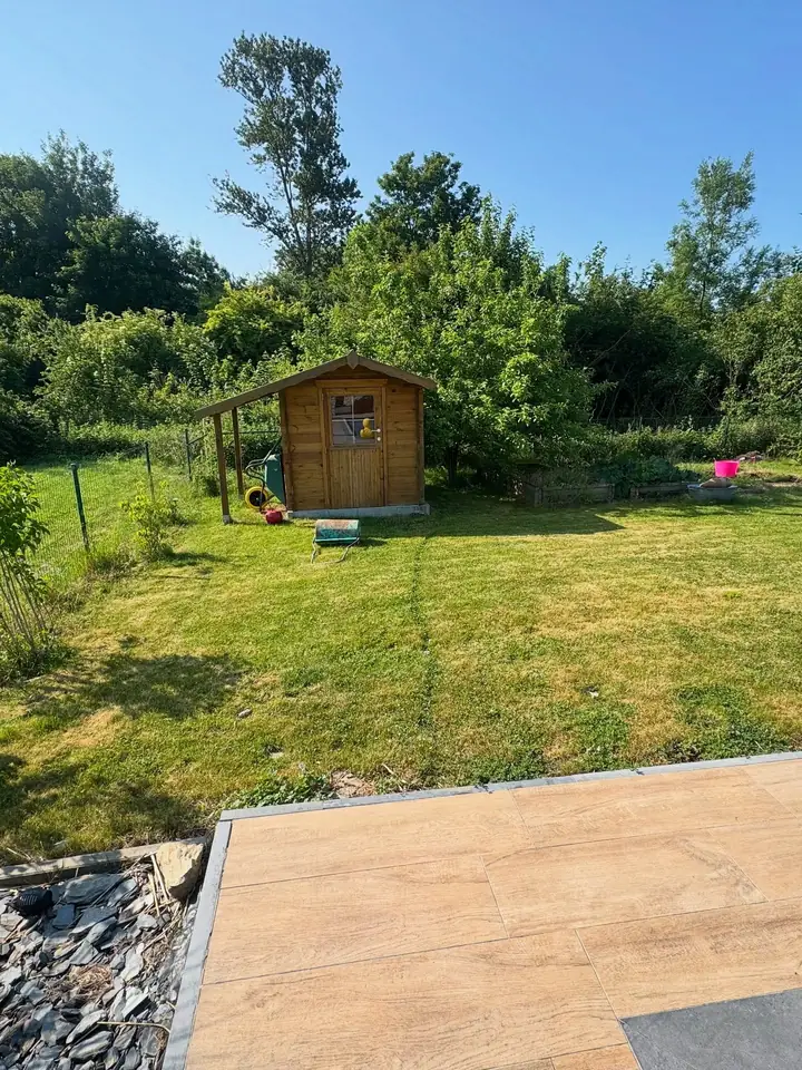 Avant travaux : pelouse et abri de jardin en bois, sans allée