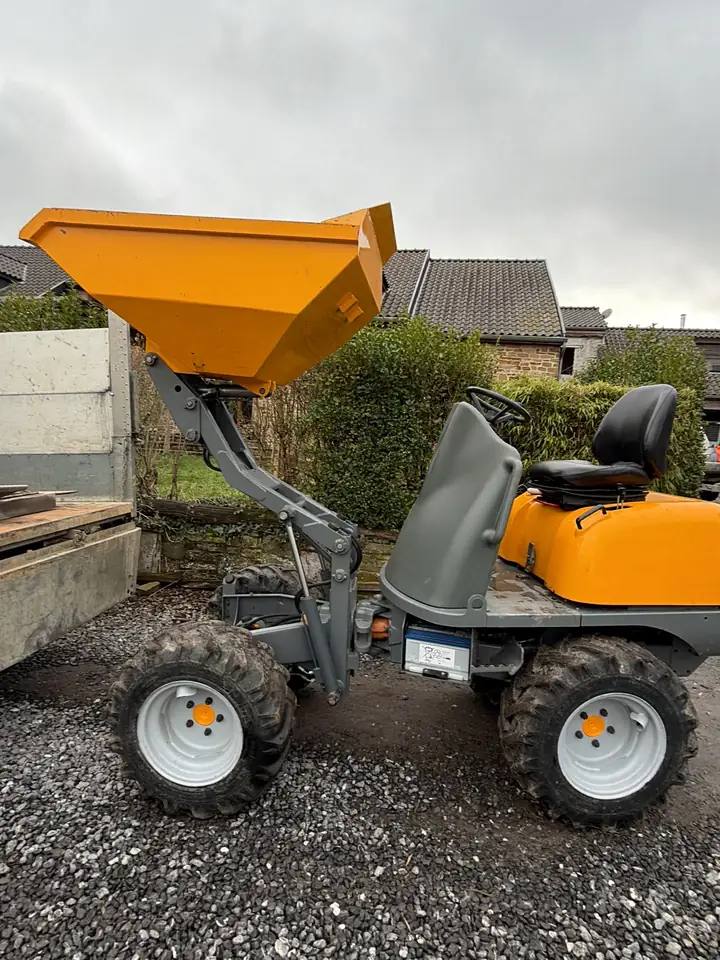 Dumper 4x4 orange à benne basculante, sur du gravier