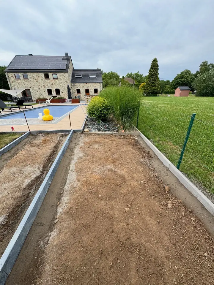 Bordures en béton posées de part et d'autre d'une future allée, près d'une piscine