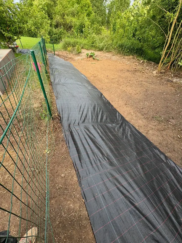 Même clôture après débroussaillage : sol dégagé et bâche anti-repousse déroulée